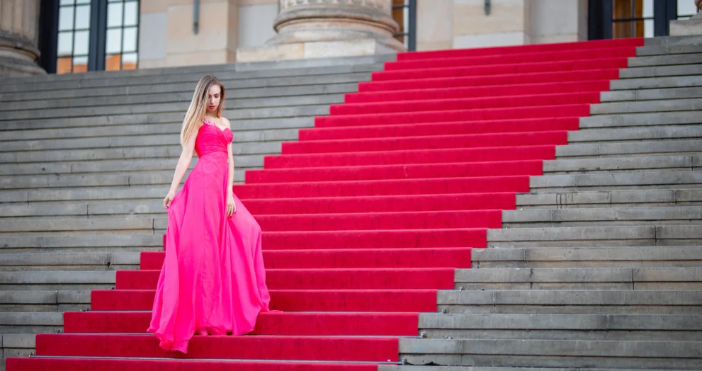 female-model-wearing-pink-evening-gown-while-standing-steps