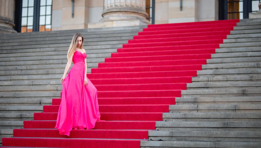 female-model-wearing-pink-evening-gown-while-standing-steps